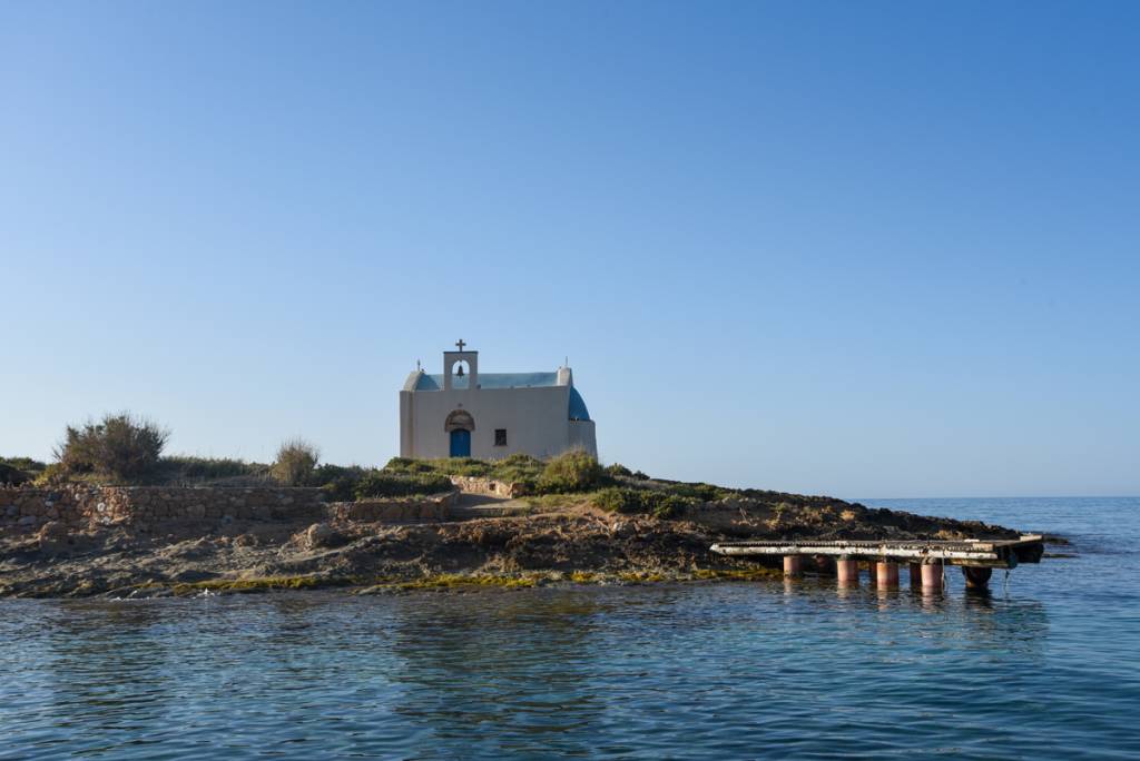 Afentis Christos Islet near Malia, Crete, with a picturesque Greek chapel surrounded
