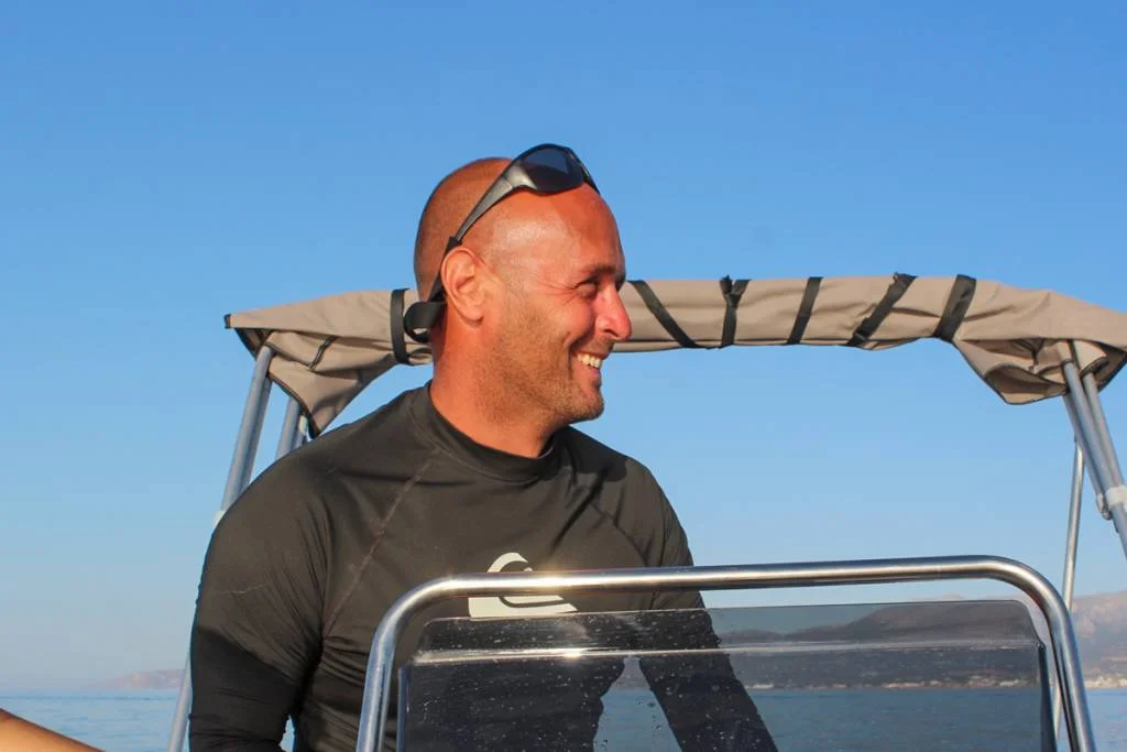 Skipper enjoying the freedom of sailing on a bareboat rental in Malia, Crete, feeling the joy and serenity of the open sea.